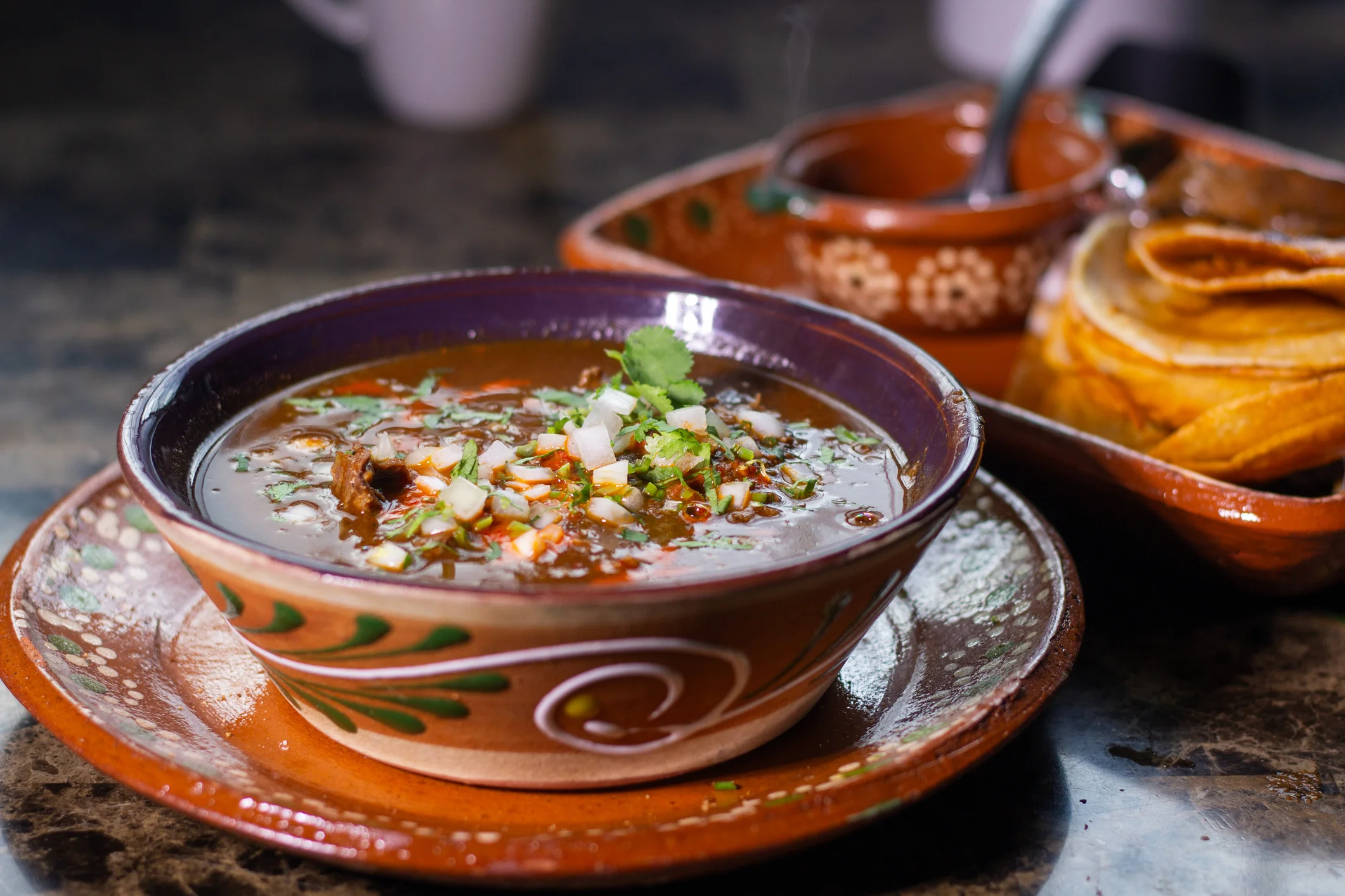 Bowl of spicy Mexican stew with tortillas.